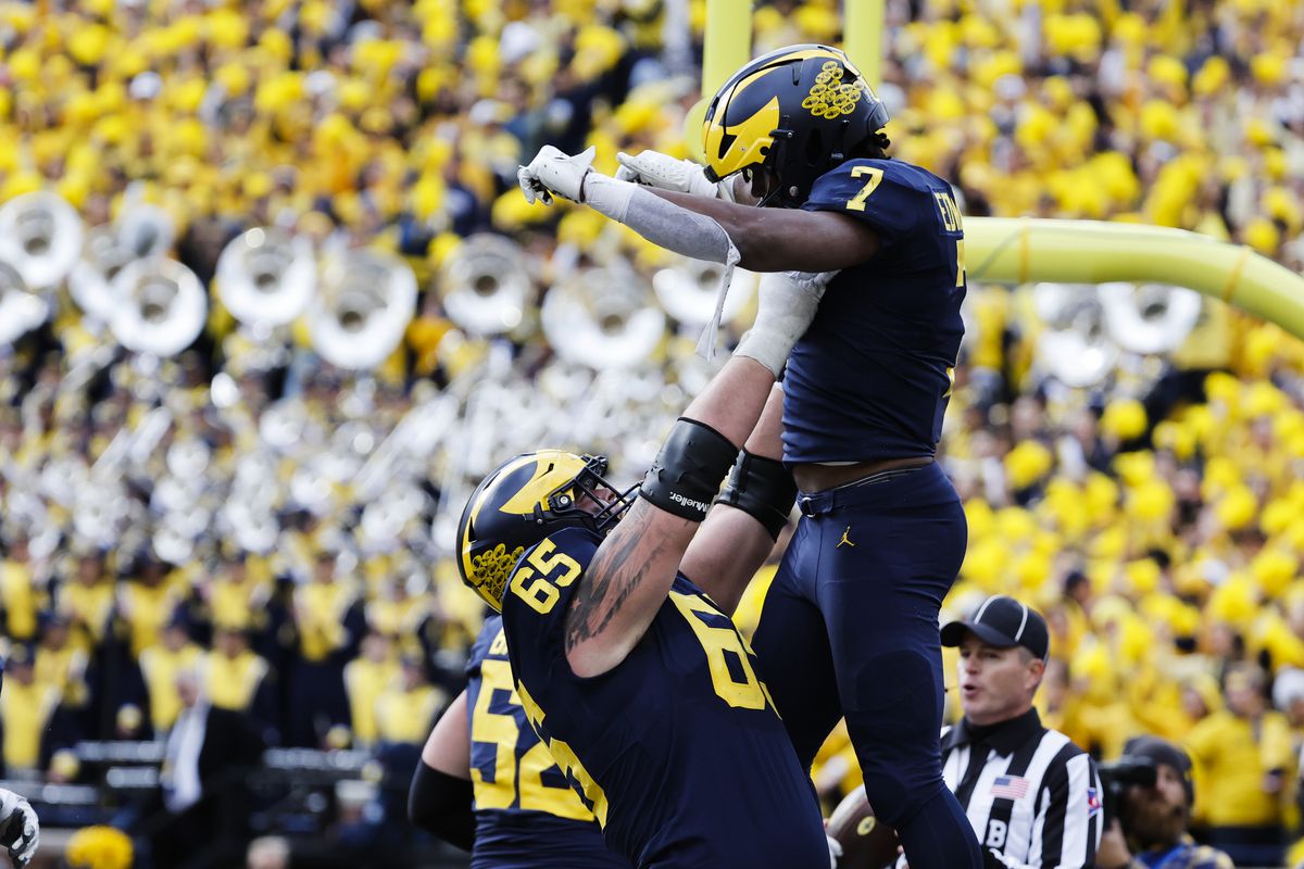 Oct 15, 2022; Ann Arbor, Michigan, USA; Michigan Wolverines running back Donovan Edwards (7) is lifted up by offensive lineman Zak Zinter (65) after he rushes for a touchdown in the second half against the Penn State Nittany Lions at Michigan Stadium.