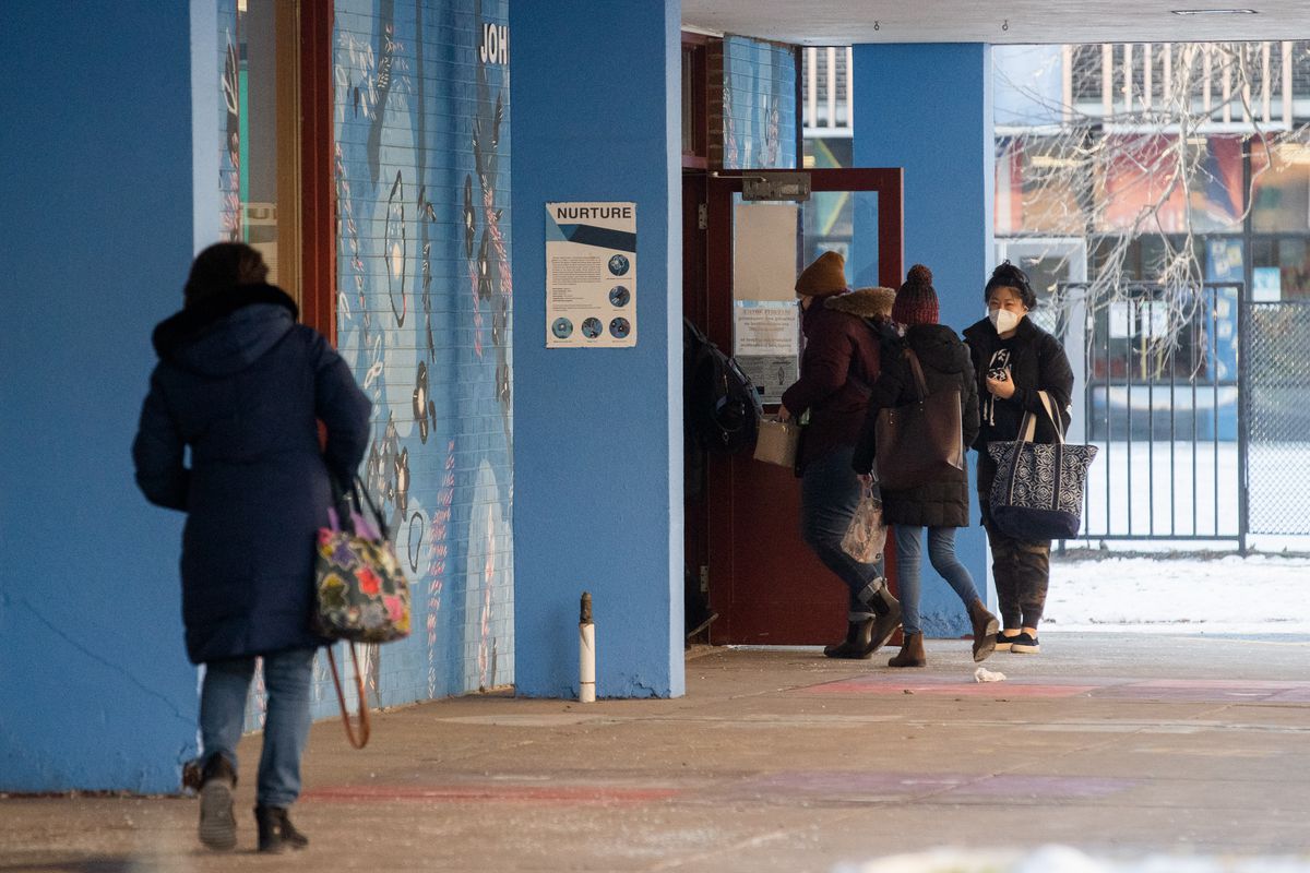 Staff members enter John T. McCutcheon Elementary School in the Uptown neighborhood, Tuesday morning, Jan. 11, 2022, after the Chicago Teachers Union’s house of delegates voted Monday night to suspend a walkout over safety concerns amid the COVID-19 Omicron surge and instead report to work in person Tuesday.