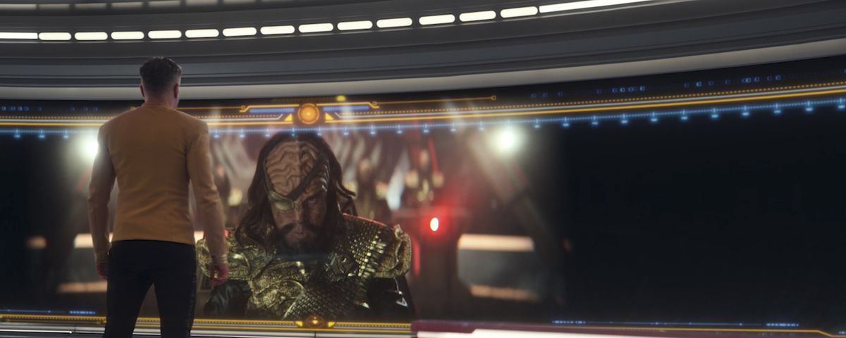 Pike (Anson Mount) standing in front of a Klingon commander on the screen