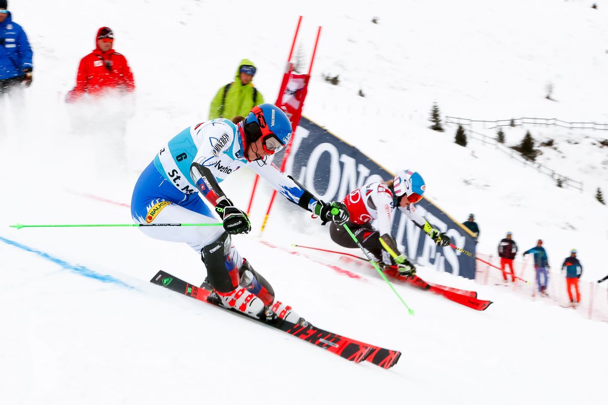 Two skiers racing around slalom gates