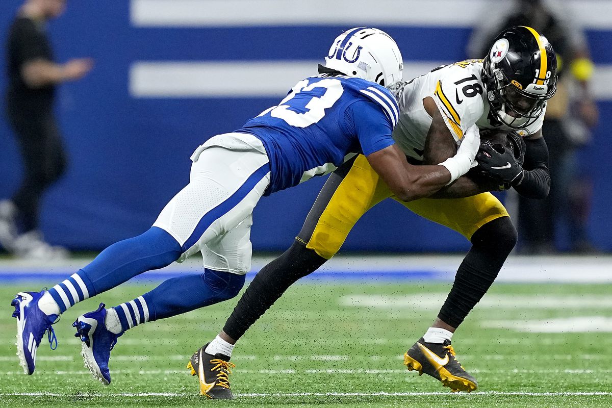 Diontae Johnson #18 of the Pittsburgh Steelers is tackled Kenny Moore II #23 of the Indianapolis Colts during the first quarter in the game at Lucas Oil Stadium on November 28, 2022 in Indianapolis, Indiana.