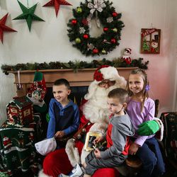 Siblings Carson, 5, Hayden, 3, and Zoie Porter, 8, of Layton, pose for a photo with Santa Claus at the Sugar House Santa Shack in Salt Lake City on Saturday, Nov. 26, 2016.