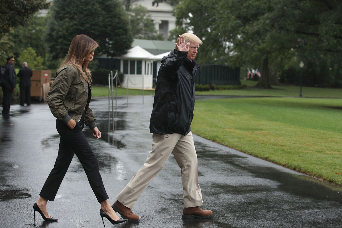 The two walk to a waiting helicopter, Melania wearing black pants, an army green jacket, and black stilettos.