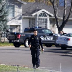FILE - Law enforcement officers patrol the area of 8800 South and 1100 West after a suspected bank robber was shot by a West Jordan police officer following a chase through a residential neighborhood on Wednesday, Nov. 2, 2016. A suspected bank robber who died following a confrontation with West Jordan police had apparently struggled with substance abuse, according to court records, and pleaded guilty to drug possession in court just five days before being shot.