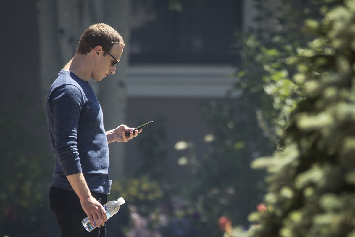 Facebook CEO Mark Zuckerberg looking at his cellphone.