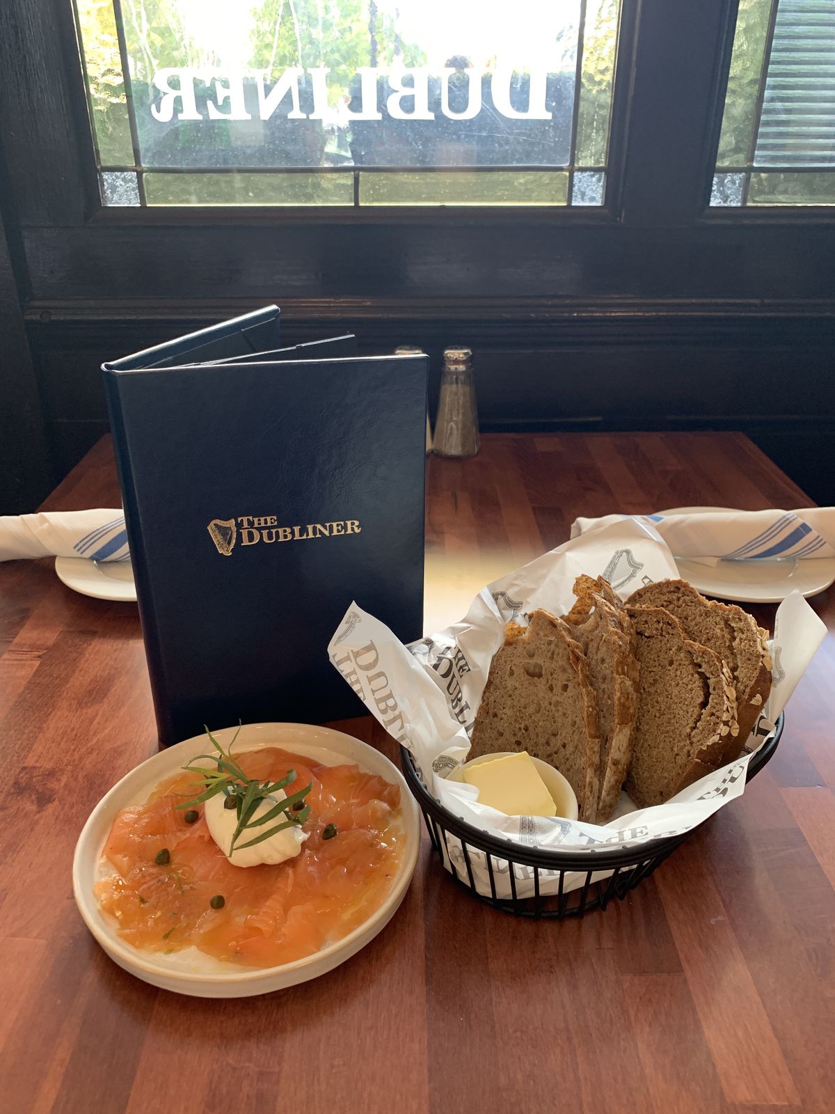 A basket of Irish breads served with a plate of smoked salmon.