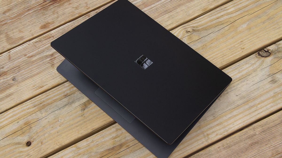 The 15-inch Surface Laptop 4 half open on a picnic table, seen from above.