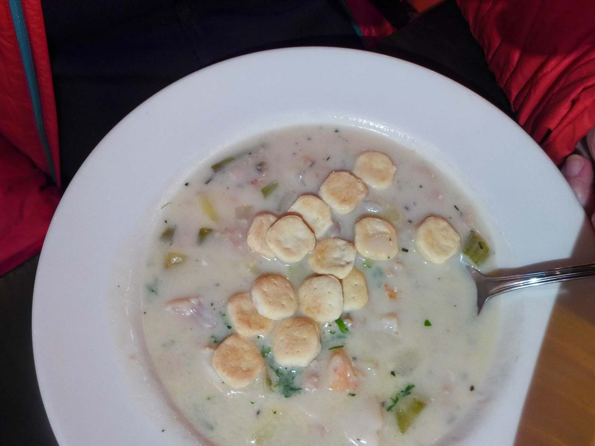 A bowl of white with oyster crackers on top.