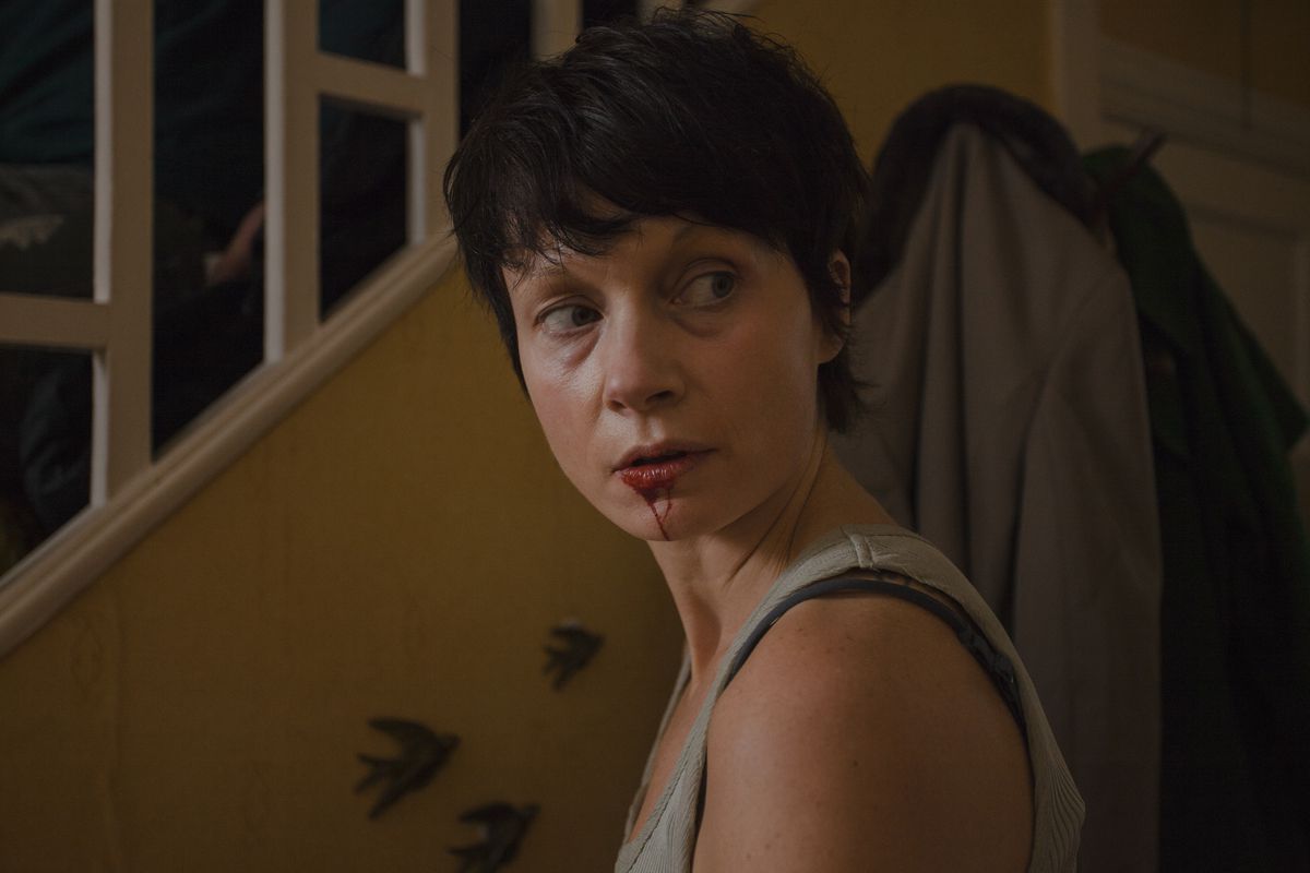 Angela (Carolyn Bracken) in a tank top looking behind her, with blood coming out of her mouth, in You Are Not My Mother