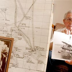 Richard G. Beckham holds a photo of the type of plane he flew in while searching over the area outlined on map, at left.