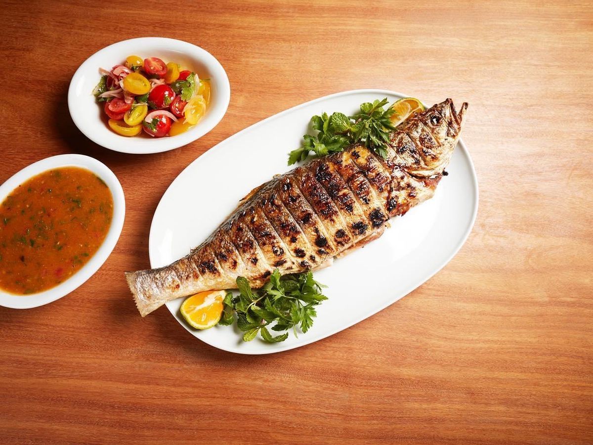 A full roasted fish with side dishes.