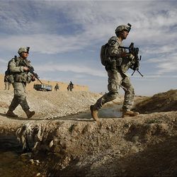 U.S. soldiers of the 4th Battalion, 23rd Infantry Regiment, 5th Brigade, 2nd Infantry Division, cross a canal west of Lashkar Gah in Helmand province, southern Afghanistan, Friday.