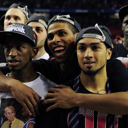 Louisville Cardinals guard Peyton Siva (right)   celebrates with teammates Russ Simth (left) and   Chane Behanan (center) after Louisville won the   championship game