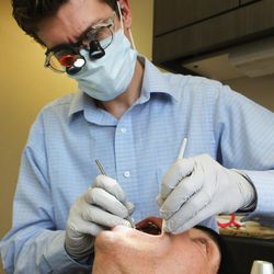 Dr. Spencer Updike of South Temple Dental conducts a free dental screening on Derick Balser in Salt Lake City on Monday, March 21, 2016. Updike gave Balser some advice on things that can be done to help with his dental health.