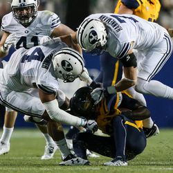 Brigham Young Cougars linebacker Fred Warner (4) and defensive back Micah Hannemann (7) tackle Toledo Rockets wide receiver Corey Jones (4) for a loss during a game at LaVell Edwards Stadium in Provo on Friday, Sept. 30, 2016.