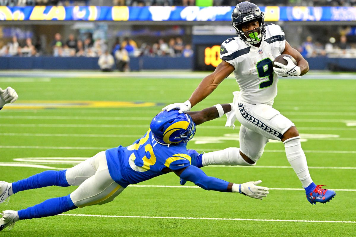 Seattle Seahawks running back Kenneth Walker III (9) runs past Los Angeles Rams safety Nick Scott (33) for a first down in the first half at SoFi Stadium.