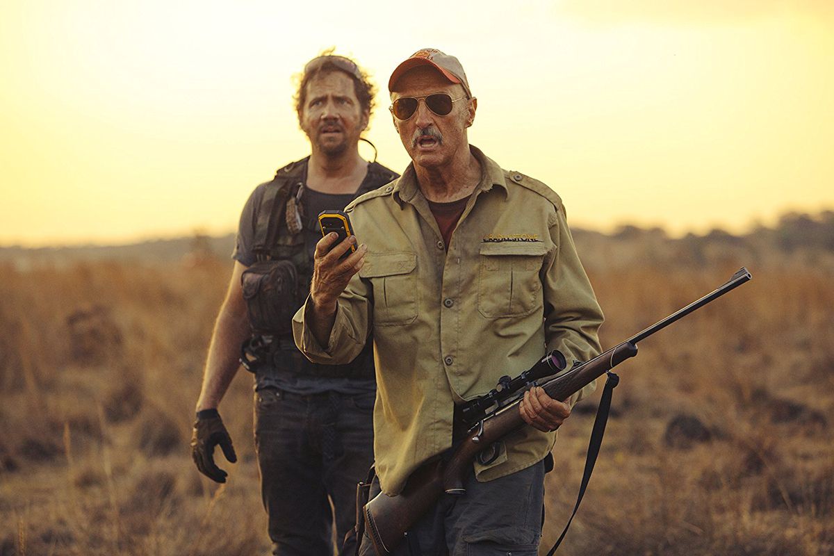 Tremors 5: Bloodline - Burt holding a scoped rifle and cellphone with Travis behind him