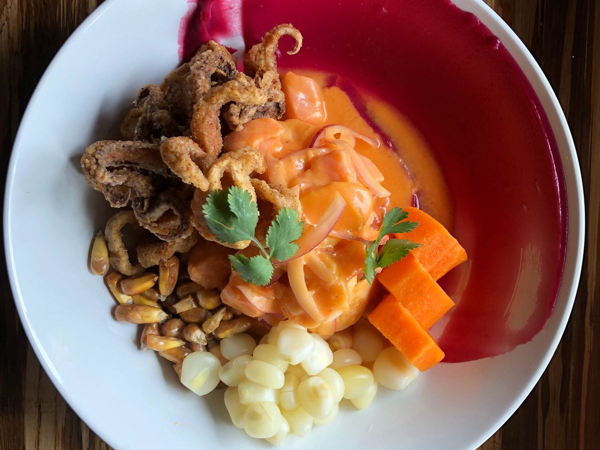 A bowl of ceviche with hunks of raw fish, sweet potato, corn, and just a touch of fried calamari