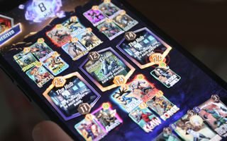 Une photo d'un jeu de Marvel Snap, mettant en vedette les emplacements The Hub et Onslaught’s Citadel, et diverses cartes, sur un iPhone