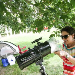 Renee Coovert, of Houston, Texas, assembles a DIY eclipse filter holder for the end of her telescope as she readies for Monday's  total solar eclipse at Weiser High School in Weiser, Idaho on Sunday, Aug. 20, 2017.
