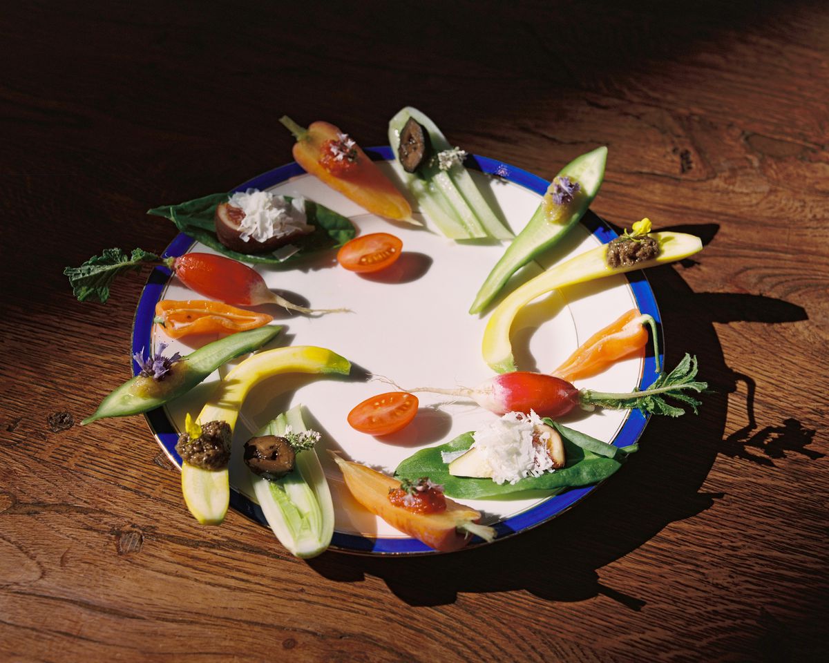 A plate with sliced vegetables with various toppings. 