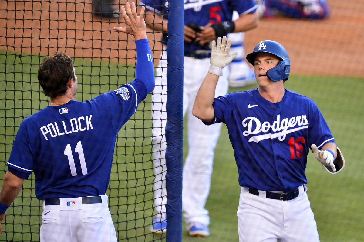 Los Angeles Dodgers catcher Will Smith maintains distance while celebrating with left fielder A.J. Pollock his two run home run during an intrasquad game at Dodger Stadium.