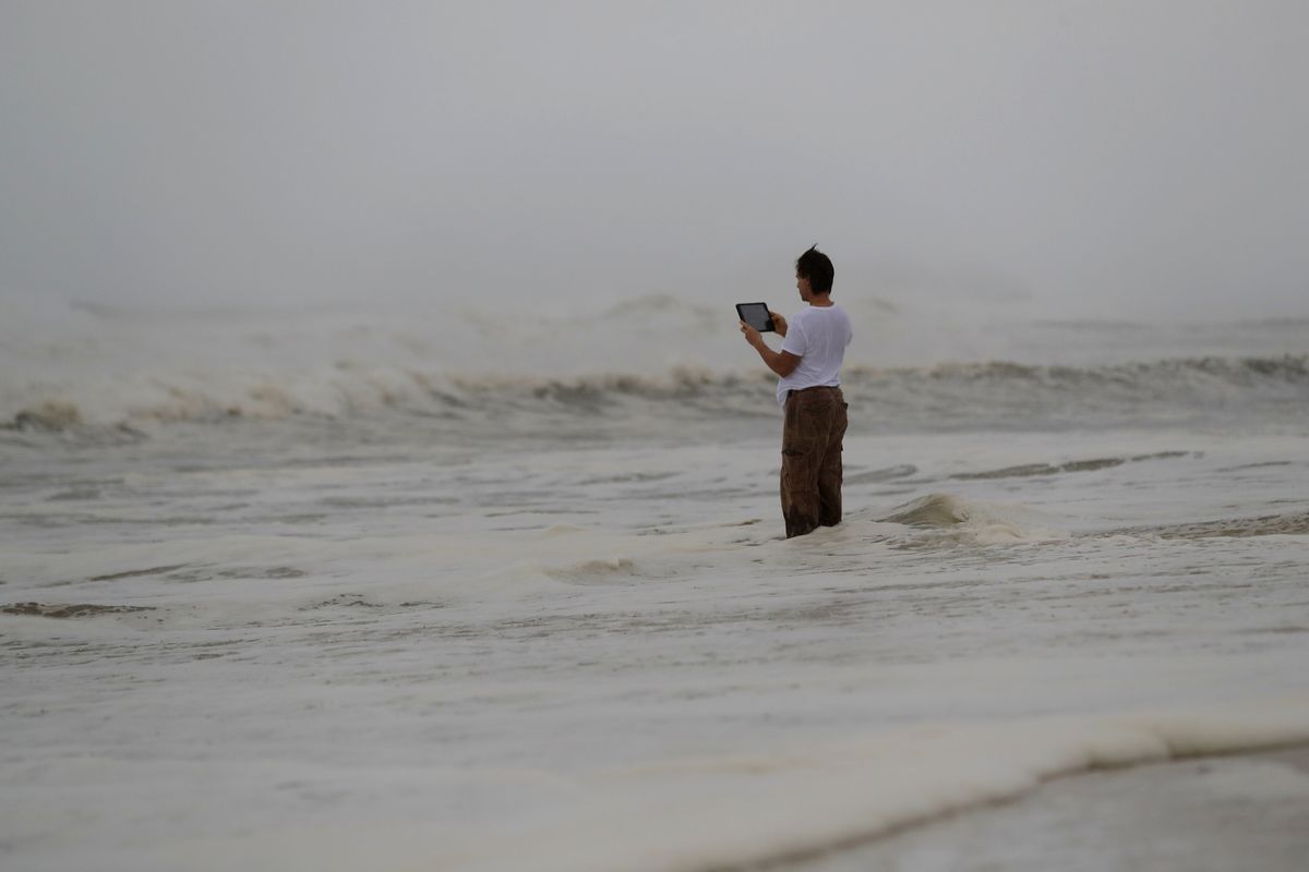 Peter Malave records the surf from encroaching Hurricane Michael in Panama City Beach, Florida, Wednesday, Oct. 10, 2018.