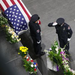Officers salute the U.S. Honor Flag as it is set next to the casket of West Valley police officer Cody Brotherson during his funeral at the Maverik Center in West Valley City on Monday, Nov. 14, 2016.