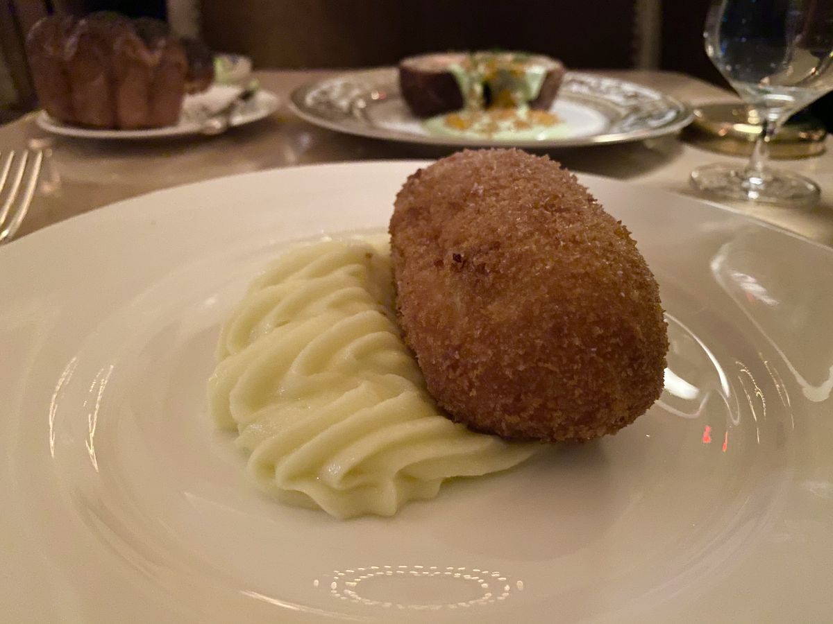 A large cylinder of boneless fried Chicken Kiev sits next to mashed potatoes at Veronika