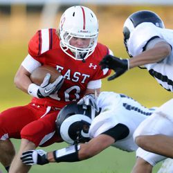 East High's Preston Curtis is tackled by Highland's Adam Webber on a stretch play during a game at Talley Stevens Stadium on Friday, September 20, 2013. 