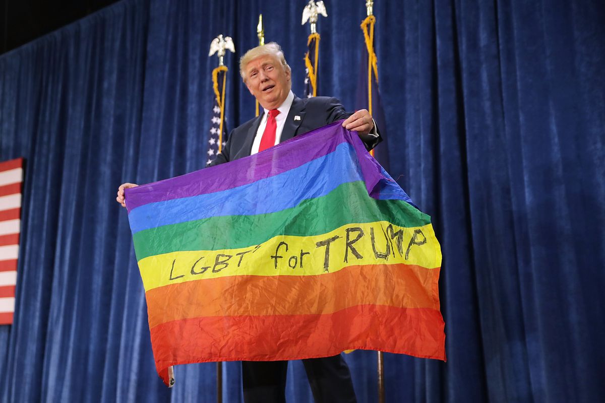 Trump holds a pride flag during a campaign event in October 2016.