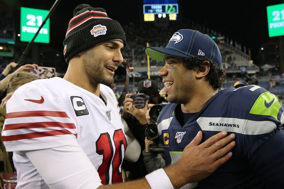Jimmy Garoppolo #10 of the San Francisco 49ers and Russell Wilson #3 of the Seattle Seahawks hug after the San Francisco 49ers defeated the Seattle Seahawks 26-21 during their game at CenturyLink Field on December 29, 2019 in Seattle, Washington.