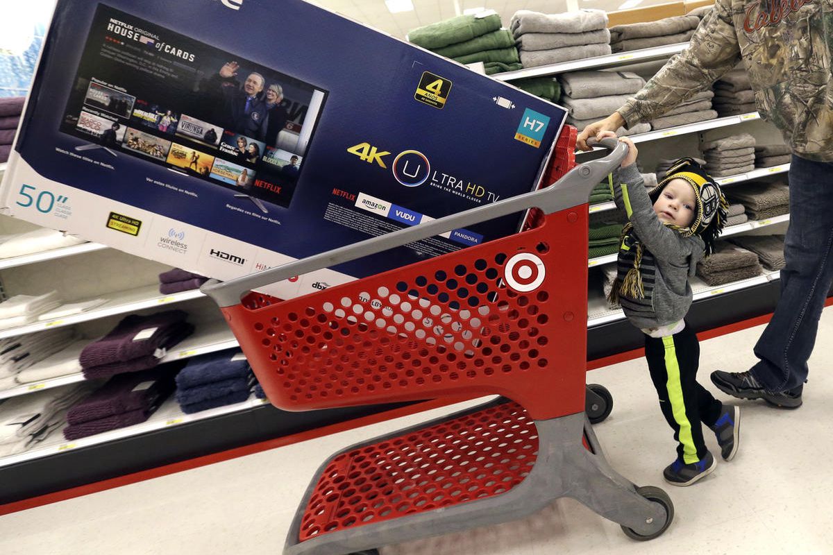 Hunter Harvey, 2, helps his dad, C.J., wheel a big screen TV at Target on Black Friday, Nov. 25, 2016, in Wilmington, Mass. Stores open their doors Friday for what is still one of the busiest days of the year, even as the start of the holiday season edges