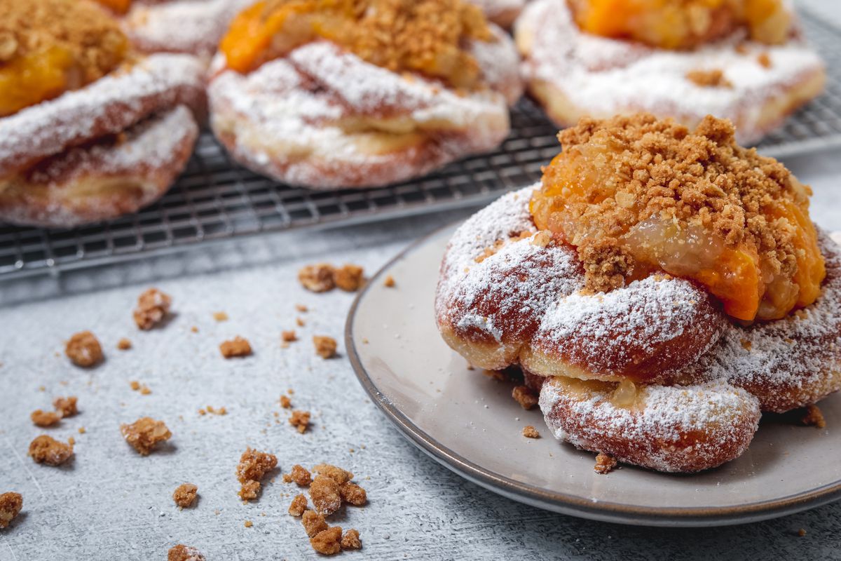 Peach funnel cake doughnut, a brioche doughnut shaped like a funnel cake topped with peach compote and brown sugar oat crumble from the Salty.