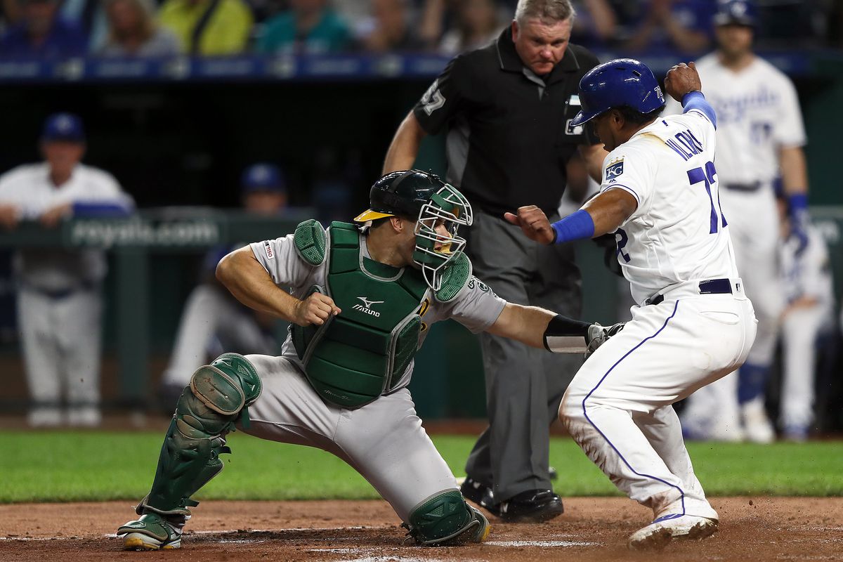 Catcher Josh Phegley #19 of the Oakland Athletics tags out Meibrys Viloria #72 of the Kansas City Royals at home plate during the 3rd inning of the game at Kauffman Stadium on August 27, 2019 in Kansas City, Missouri.