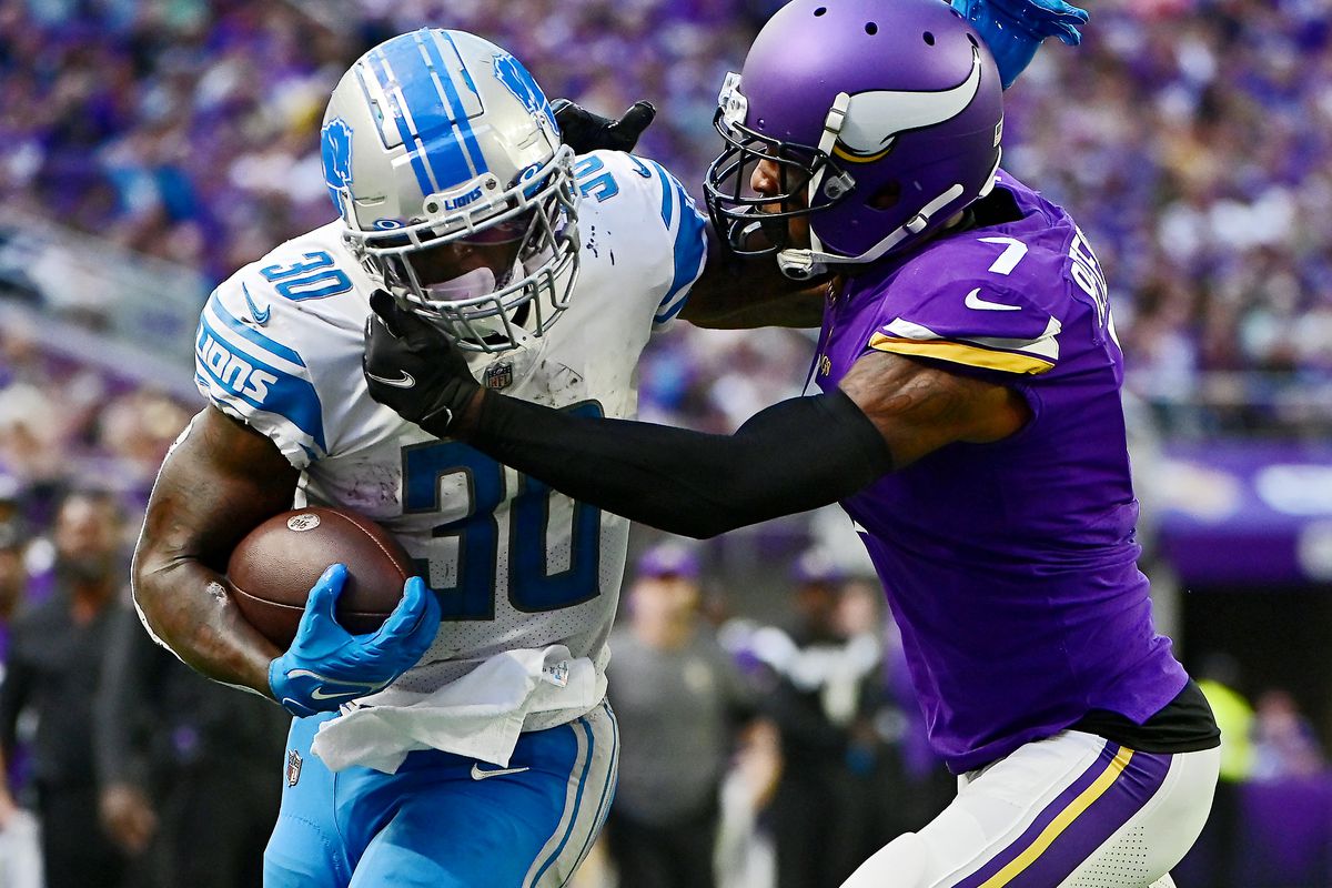 Running back Jamaal Williams #30 of the Detroit Lions fights his way with cornerback Patrick Peterson #7 of the Minnesota Vikings into the end zone for a touchdown in the third quarter of the game at U.S. Bank Stadium on September 25, 2022 in Minneapolis, Minnesota.