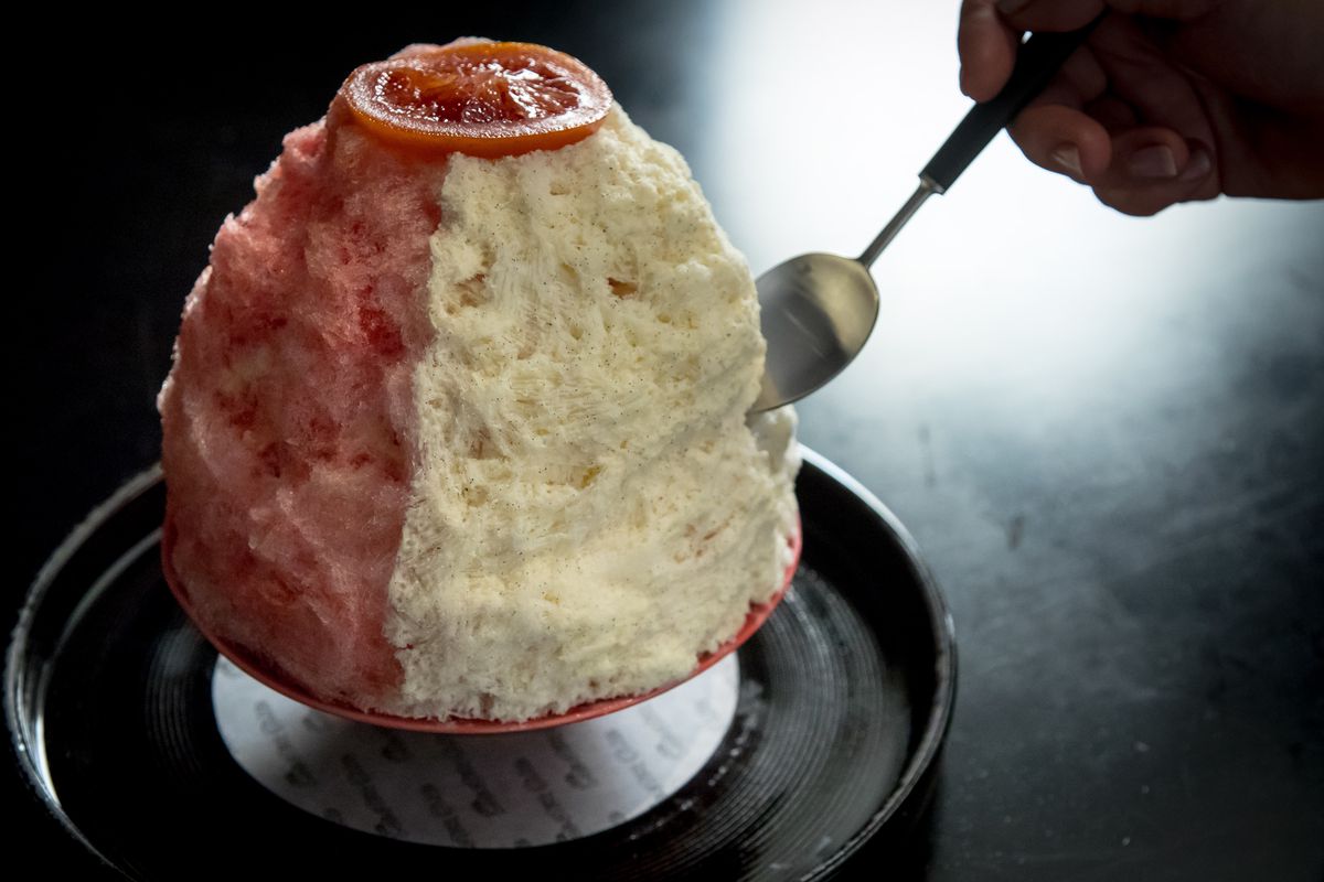 Mountain of shaved ice, orange on one side and vanilla on the other.