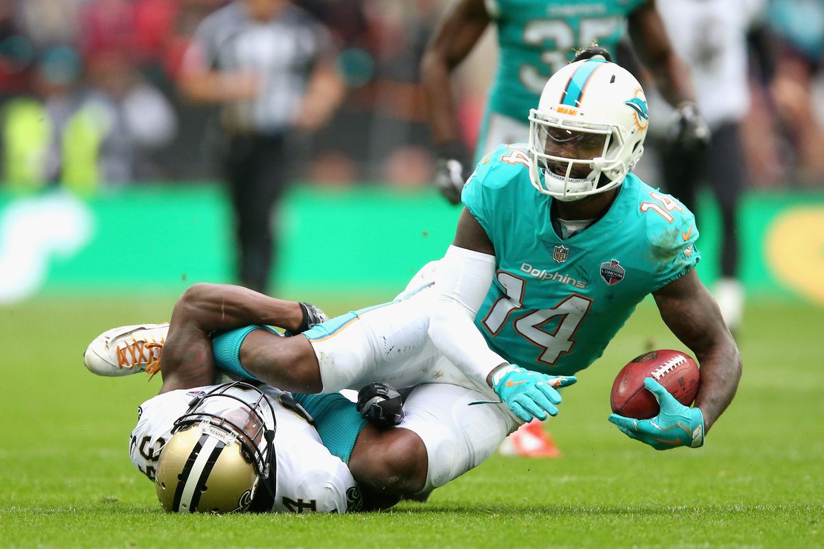 LONDON, ENGLAND:  New Orleans Saints defensive back Justin Hardee (34) is tackled by Miami Dolphins wide receiver Jarvis Landry (14) during an NFL International Series match at Wembley Stadium.