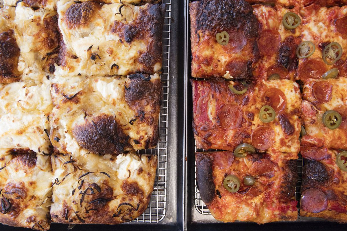 Overhead view of two rectangular pizzas on metal racks