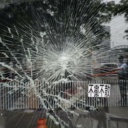 Police officers stand guard near a broken glass outside Legislative Council building in Hong Kong, Tuesday, July 2, 2019. Hundreds of protesters swarmed into Hong Kong's legislature Monday night, defacing portraits of lawmakers and spray-painting pro-democracy slogans in the chamber before vacating it as riot police cleared surrounding streets with tear gas and then moved inside. The words read " not leave, not withdraw." (AP Photo/Vincent Yu)
