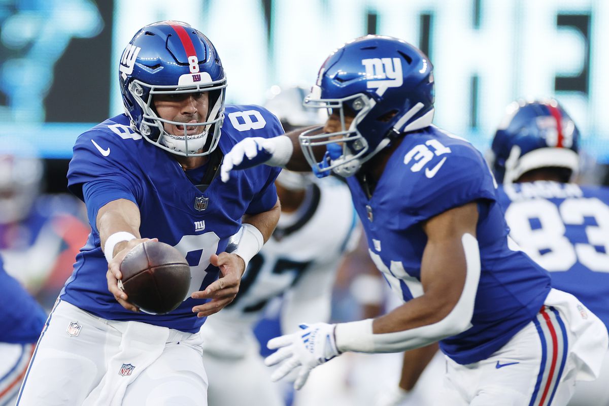 Daniel Jones #8 of the New York Giants hands the ball off to Matt Breida #31 during the first half of a preseason game against the Carolina Panthers at MetLife Stadium on August 18, 2023 in East Rutherford, New Jersey.