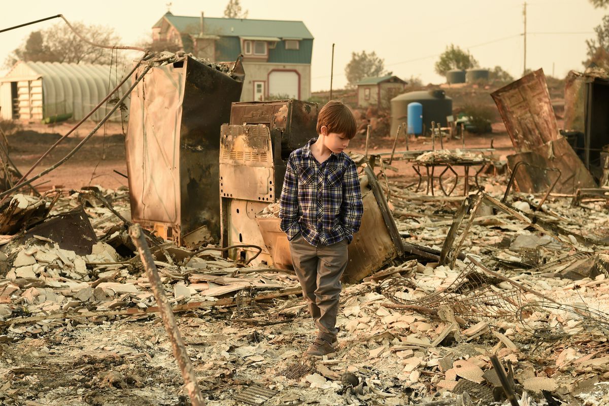 Jacob Saylors, 11, walks through the burned remains of his home in Paradise, California on November 18, 2018 after the Camp Fire tore through the town. The family lost a home in the same spot to a fire 10 years prior.
