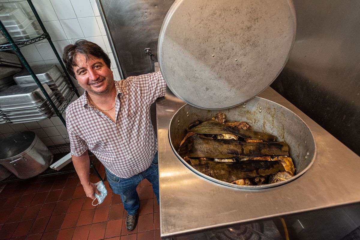 Paco Pérez holding open his specially engineered barbacoa pit oven inside Aqui es Texcoco.