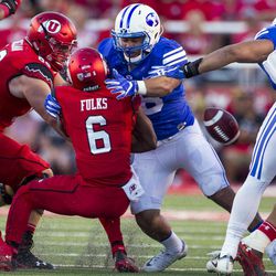 BYU linebacker Butch Pau'u (center) tackles a Utah opponent in the rivalry game.