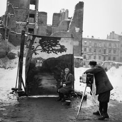 A photographer uses his own backdrop to mask Poland's World War II ruins while shooting a portrait in Warsaw in November of 1946.