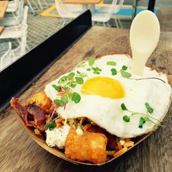Crisp Tots & Local Egg (chili butter, cheddar cheese, herbed goat cheese, avocado crema sauce, bacon, micro greens)