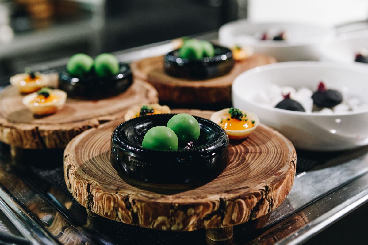 Spherified olives presented on a wood board