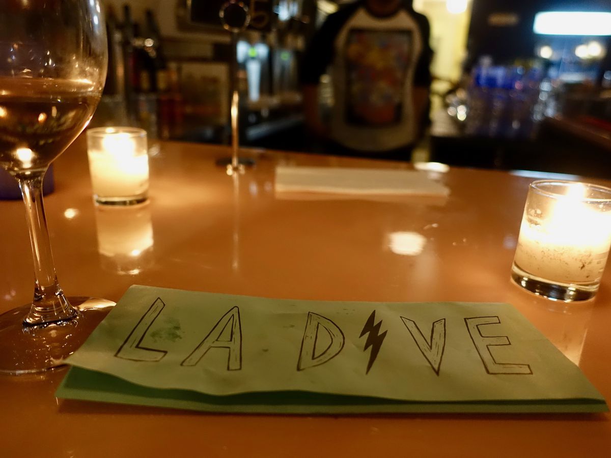 A candlelit table at La Dive, with a green menu displayed.