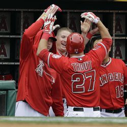 Los Angeles Angels congratulate teammate Mike Trout (27) after his home run against the Houston Astros in the third inning of an interleague baseball game in Anaheim, Calif., Sunday, April 14, 2013. 