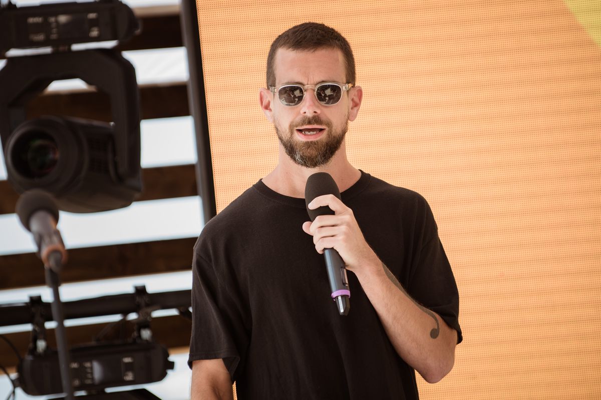 Jack Dorsey wears sunglasses and speaks into a handheld microphone onstage at Cannes.
